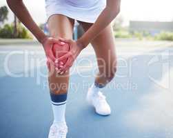 Injuries are a part of life. an unrecognisable woman suffering an injury while playing tennis.