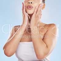 Closeup face beautiful young mixed race woman. Attractive female touching her face in studio isolated against a blue background. A skincare regime to keep your skin soft, smooth, glowing and healthy