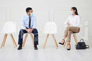 Two businesspeople wearing face mask while waiting for interview. Asian businessman and mixed race businesswoman keeping social distance. Candidate in line for job opening, vacancy, office opportunity