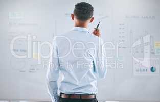 One businessman from behind brainstorming and planning with graphs, stats and analytics on a whiteboard. Mixed race guy thinking of ideas and strategies while doing market research for his startup