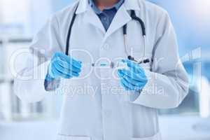 doctor wearing a labcoat and gloves preparing a covid vaccine while working in a hospital. Unrecognizable scientist removing liquid from a vial using a syringe while working at a lab