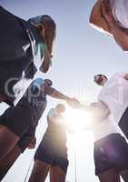 Below two opponent rugby teams shaking hands before or after a match outside on a field. Rugby players sharing a handshake to show respect and sportsmanship. A mutual understanding of the game