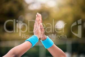 Hands of tennis players high five after a match. Closeup on hands of tennis players celebrating after a successful match. Tennis players motivate each other after practice.