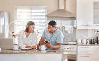 Calculating our monthly expenses. Shot of a couple going over paperwork together at home.