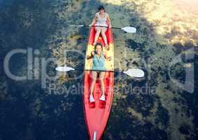 Above view of two smiling friends kayaking on the ocean together over summer break. Portrait of happy women canoeing and bonding outside in nature with water activity. Having fun on a kayak