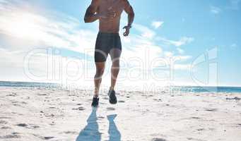 Fit young black man running and jogging at the beach in the morning while exercising. Closeup of one strong muscular male athlete with six pack abs doing cardio workout to build muscle and endurance