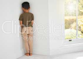 There are different ways to discipline a child. Shot of a little boy standing in a corner at home.