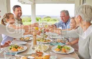 Heres to more life. Shot of a family toasting during a sunday lunch.