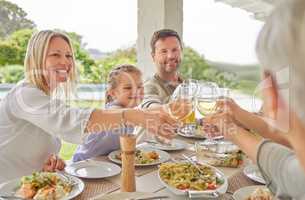 To health and wellness. Shot of a family toasting during a sunday lunch.