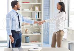 Two mixed race businesspeople in handshake after signing contract in interview. Asian applicant meeting CEO and hiring manger. Candidate hired for job opening, vacancy, office opportunity, promotion