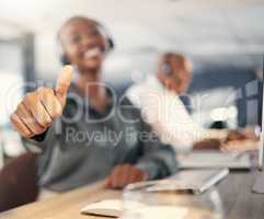 Closeup of african american call centre telemarketing agent gesturing thumbs up for approval and success in an office. Hands of happy female consultant determined to give good customer service and best sales support