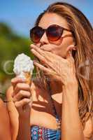 You have to treat yourself. Shot of a beautiful young woman enjoying an ice cream cone.