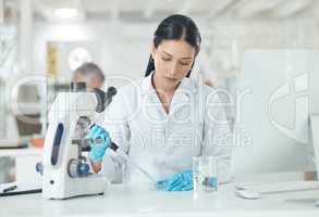 Setting up for a new clinical trial. a young scientist working with samples in a lab.