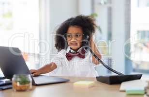 Let me find that for you. Shot of an adorable little girl dressed as a businessperson sitting in an office and using a laptop and telephone.