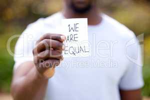 Womens rights are not only an abstraction. Shot of a unrecognizable man holding a card in protest in a park.