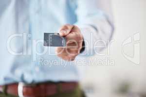 Businessman holding a credit card. Closeup of hand of businessman holding a debit card. Zoom into hand of businessman using card to make online payments. Card used for online, ecommerce shopping