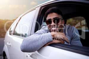 Create your story. Shot of a handsome young man enjoying an adventurous ride in a car.