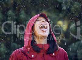 Without rain, there wont be rainbows. a young woman sticking out her tongue to feel the rain outside.