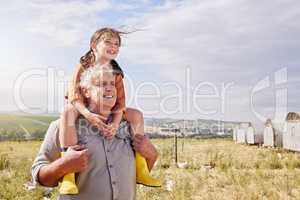 One day this will all be yours. a mature man bonding with his granddaughter on a poultry farm.