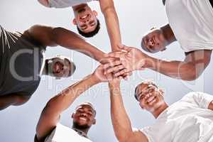 Portrait of sporty men stacking hands in a huddle for team support, collaboration and unity from below. Group of cheerful and motivated athletes joining together in a circle for encouraging pep talk