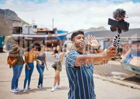 Hey guys Im hanging out with my crew today. a young man using a digital camera on a tripod while hanging out with his friends outdoors.