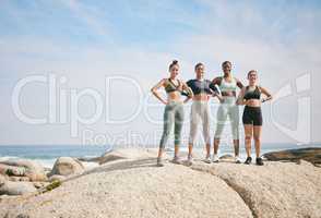 We are enough as we are. a group of friends standing on a boulder during a workout.