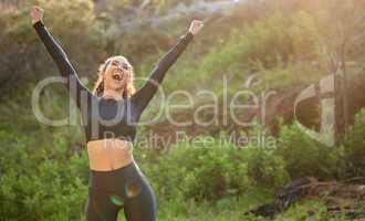 Yell with me. Shot of a young woman celebrating her progress while out on her morning run outside.