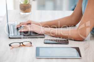 Closeup of mixed race business womans hands and fingers typing on laptop keyboard at a table in an office. One female only sending emails while busy with research and planning online for her startup