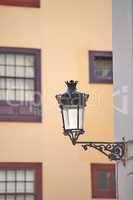A street lamp or light on the side of a building in the historic and tourist town of Santa Cruz, La Palma, Canary Islands. Illuminating the roads so traveling tourists can see the sights and views