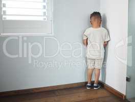 He hates not getting his way. Shot of an unrecognizable little boy facing the wall and as punishment in a room at home.