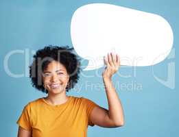 Speak up. an attractive young woman standing alone against a blue background in the studio and holding a chat bubble.