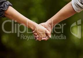 A walk on the wild side. Closeup shot of an unrecognizable couple walking hand in hand through the wilderness.
