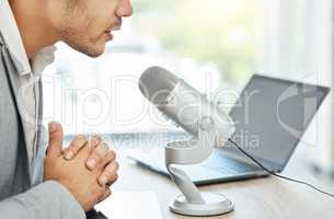 Lets keep the conversation going. Closeup shot of a businessman using a microphone during a broadcast in an office..