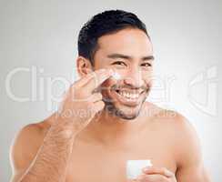 Regular use for results you can see. Studio shot of a handsome young man applying moisturiser against a grey background.