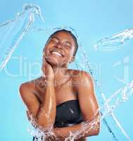 But youll stay for her softness. Shot of a beautiful young woman being splashed with water against a blue background.