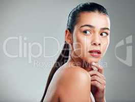 Its hard not to notice. Studio shot of a beautiful young woman posing against a grey background.