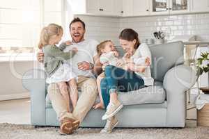 In time of test, family is best. Shot of a young family playing together on a sofa at home.