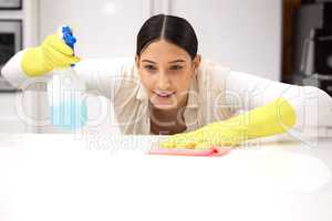 Theres no way Im missing a spot. a young woman smiling while cleaning a kitchen counter.