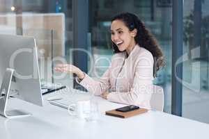 A smiling mixed race call centre agent looking happy and positive while wearing a headset. Female customer service worker using headset and consult with clients online while sitting at office desk