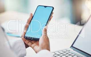 Above closeup african american woman doctor using her smart phone while working at a desk in her hospital office. Using wireless technology to diagnose diseases in the field of health and medicine