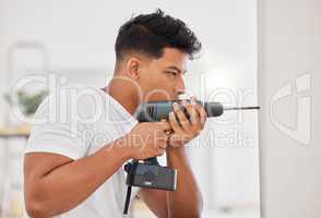 This is where I need the hole. Shot of a man using a cordless drill on a wall.