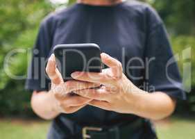 Closeup of someone typing on a phone outside in nature. A person texting and using facebook. Someone using a mobile phone device and browsing the internet