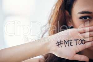 Lets all stand up against sexual abuse. Closeup shot of a young woman with the hashtag me too written on her hand.