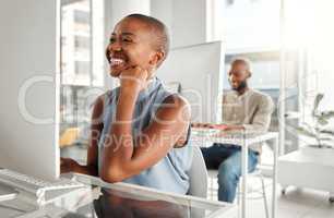 Young joyful african american businesswoman using a desktop computer in an office at work. Cheerful black female businessperson reading an email at a desk. Business professional working on a computer