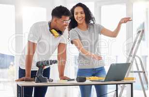 With the help of the internet, anyone can be an expert. Shot of a young couple using a laptop while busy renovating a house.
