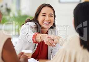 Team of smiling diverse business women shaking hands in office after meeting in boardroom. Group of happy professionals and colleagues using handshake and gesture to congratulate success and welcome