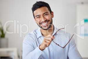 Portrait of a mixed race cheerful businessman removing his glasses while relaxing at his office job . Hispanic man financial advisor smiling while waiting to meet with clients