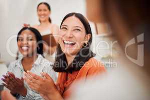 Happy young hispanic businesswoman clapping hands during a meeting in an office boardroom with colleagues. Cheerful excited woman applauding to celebrate an inspiring presentation and successful deal in a creative startup agency