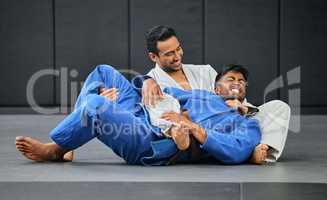 Two judo competitors fighting during practice. Martial arts coach training his student. Two judo competitors fighting during practice. Martial arts coach training his student.