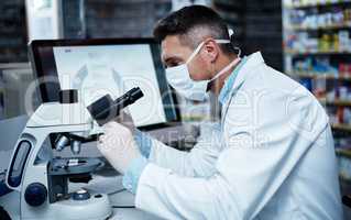 The leader in cutting edge pharmaceutical research. a mature man using a microscope while conducting pharmaceutical research.